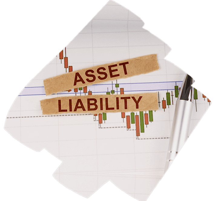 A financial chart with green and red bars, indicative of market data, overlaid with two pieces of tape crossing each other. On the tape, the words “ASSET” and “LIABILITY” are written in capital letters. A pen lies diagonally across the chart, suggesting analysis or work on asset/liability management.